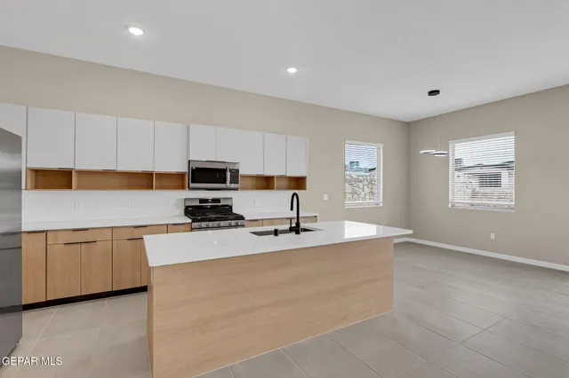 a kitchen with stainless steel appliances granite countertop a stove a sink and a refrigerator