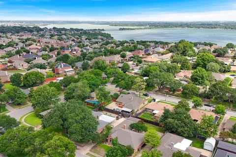 an aerial view of a city with lots of residential buildings ocean and mountain view in back