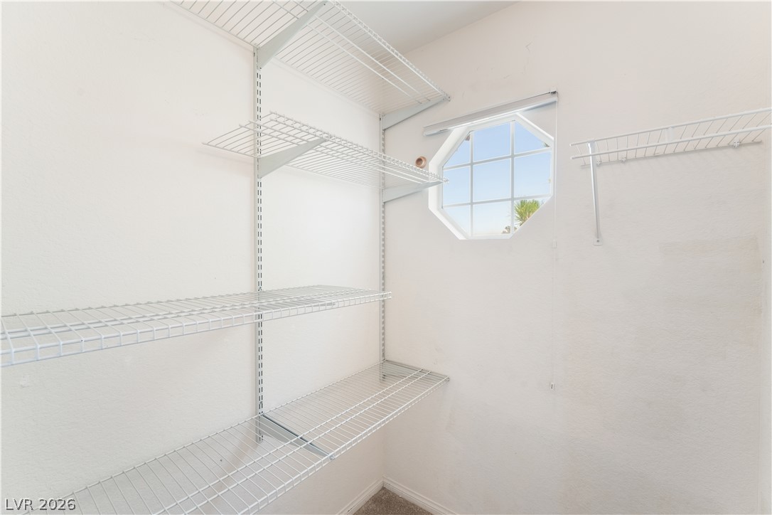 8872 Chapman Point Las Vegas, NV 89129 - Photo 20 of 29 Functional wire shelving and an octagonal window create a well-organized closet space.
