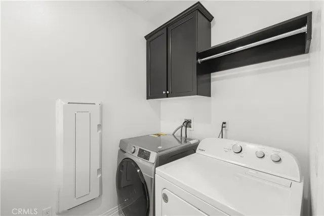 a view of washer and dryer with kitchen in the background