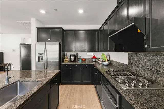 a kitchen with stainless steel appliances granite countertop a sink stove and refrigerator