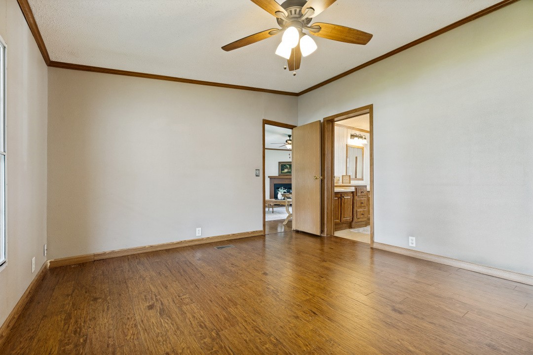 207 Vivian Road Onalaska, TX 77360 - Photo 20 of 34 an empty room with wooden floor fan and windows