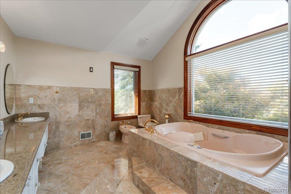 3543 Cedar Brook Drive Rochester, MI 48309 - Photo 69 of 99 Vaulted ceilings, large arched window, tiled flooring, tiled bath surround, and a dual vanity with a granite-finish countertop