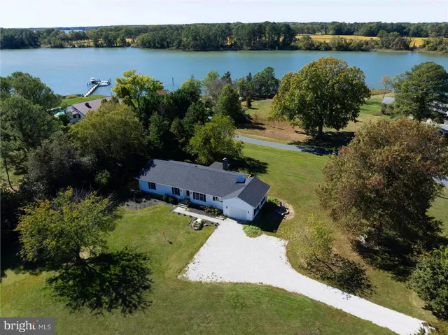 an aerial view of a house with garden space and lake view