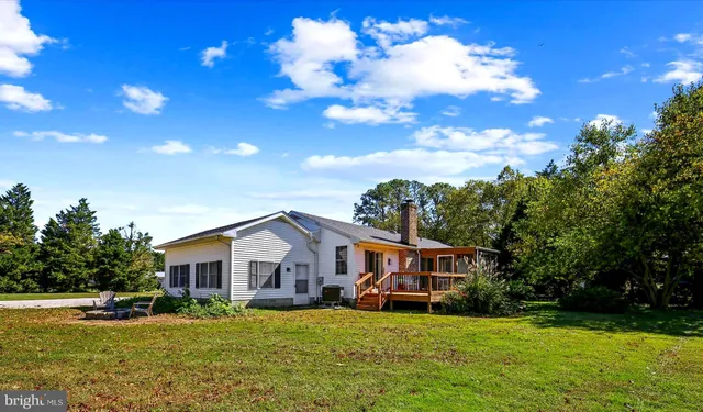 a front view of a house with a garden and trees