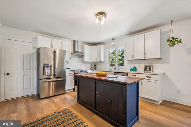 a kitchen with stainless steel appliances granite countertop a refrigerator and a stove top oven