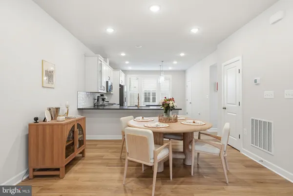 a kitchen with stainless steel appliances kitchen island granite countertop a sink a stove a dining table and chairs