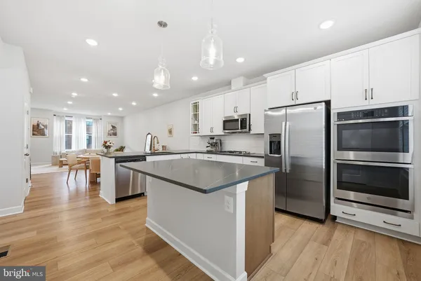 a kitchen with stainless steel appliances granite countertop a refrigerator a stove top oven and a sink