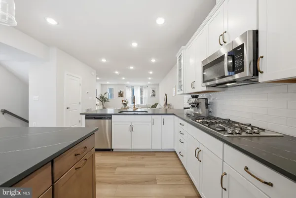 a kitchen with stainless steel appliances granite countertop a sink and stove top oven