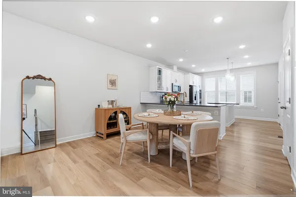a large kitchen with dining table chairs and a counter top space