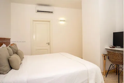 a bedroom with a bed and a television