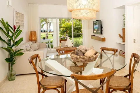 a dining room with furniture and large windows