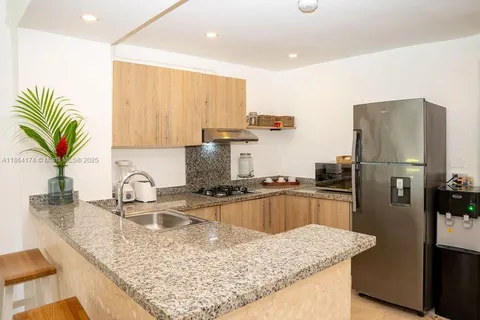 a kitchen with stainless steel appliances granite countertop a sink refrigerator and microwave