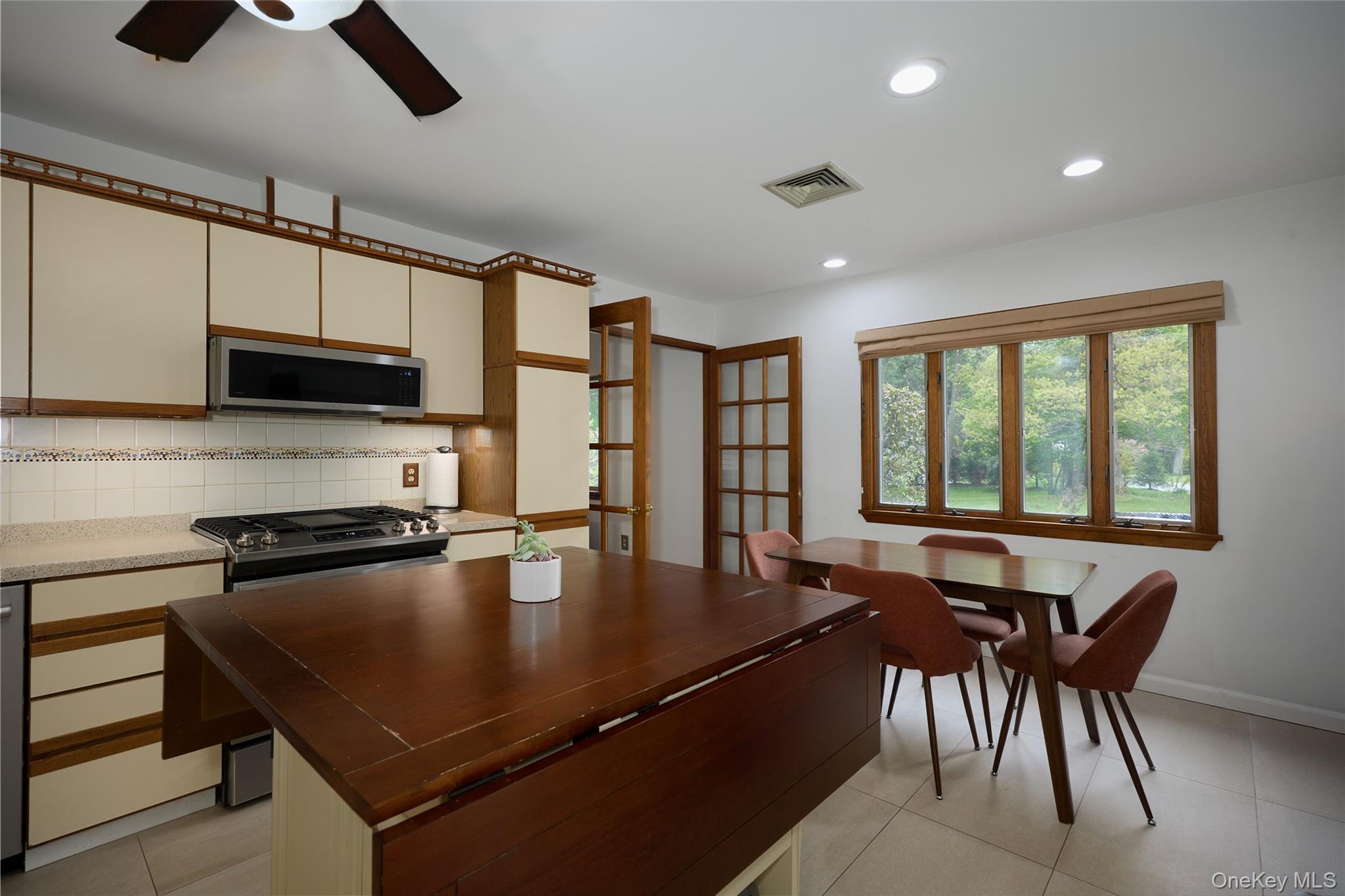 34 Maple Brook Road Tuxedo Park, NY 10987 - Photo 7 of 25 a kitchen with a table chairs microwave and cabinets
