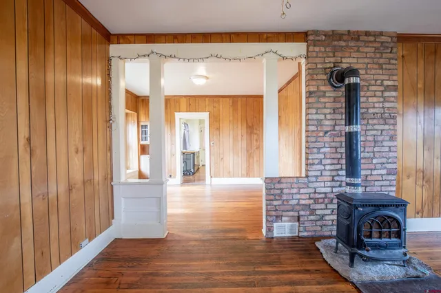 a view of a entryway door with hallway and wooden floor