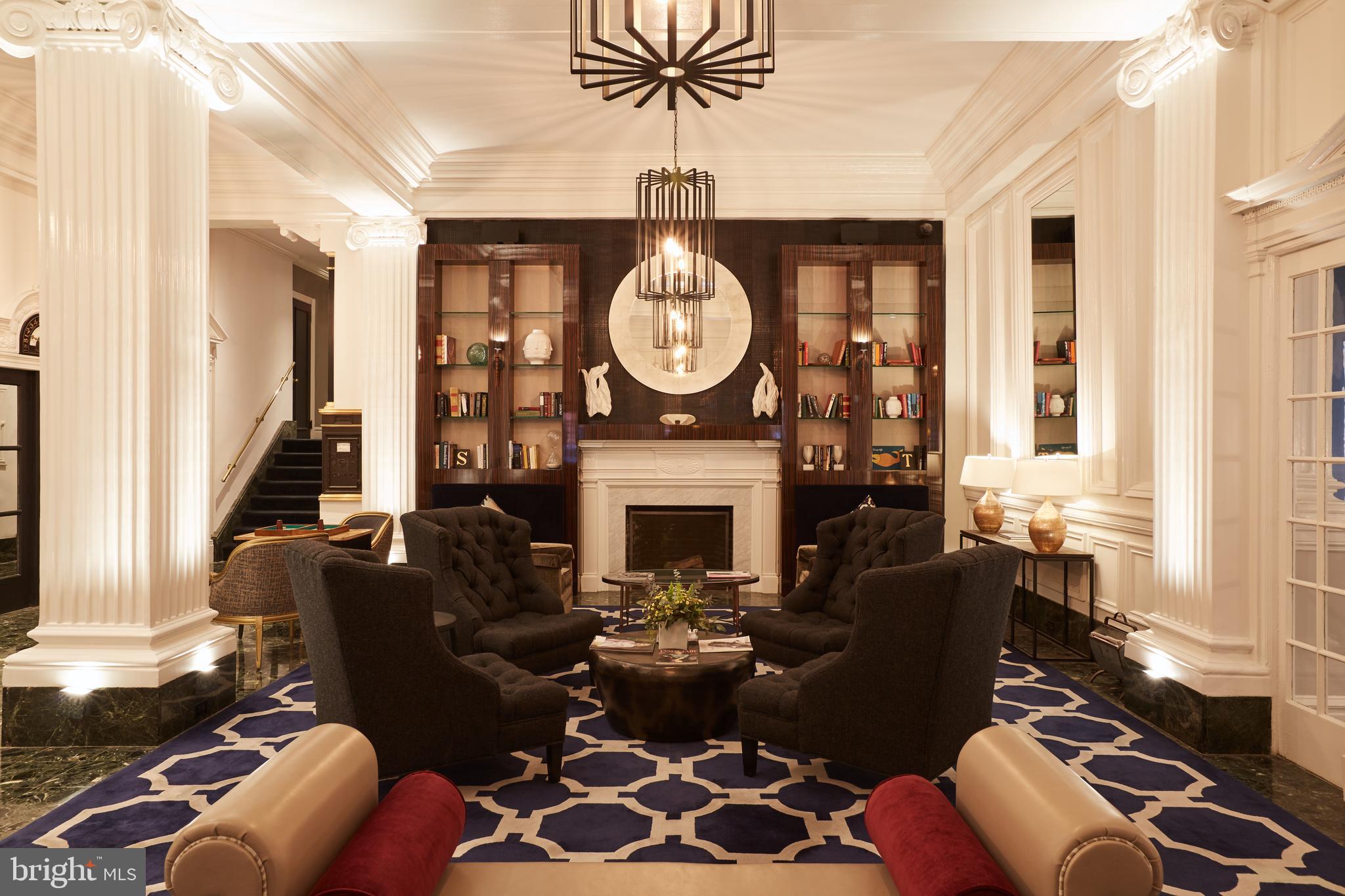 1520-28 Spruce Street, Unit 202 Philadelphia, PA 19102 - Photo 13 of 24 a living room with furniture a fireplace a chandelier and a window