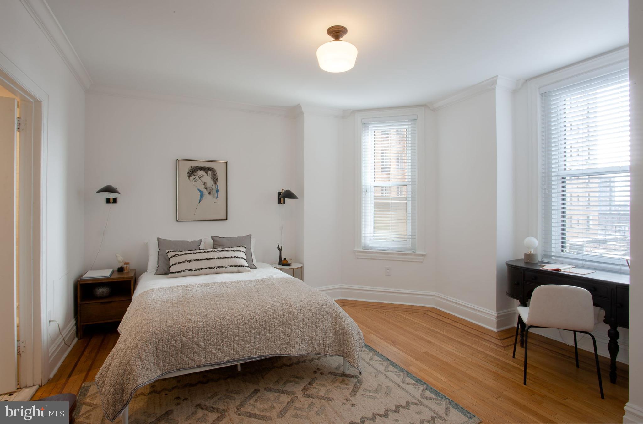 1520-28 Spruce Street, Unit 202 Philadelphia, PA 19102 - Photo 4 of 24 a bedroom with a bed and a chair with window
