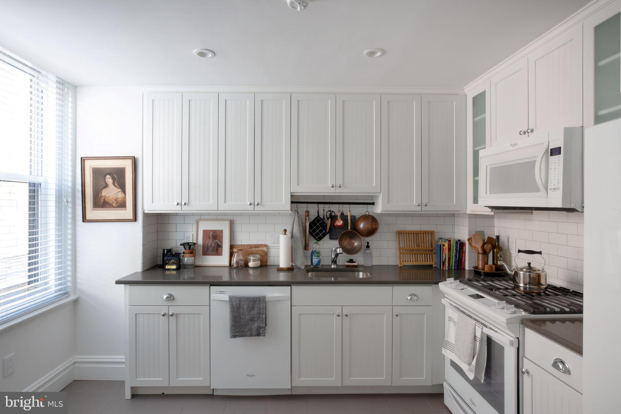 1520-28 Spruce Street, Unit 202 Philadelphia, PA 19102 - Photo 9 of 24 a kitchen with white cabinets and white appliances