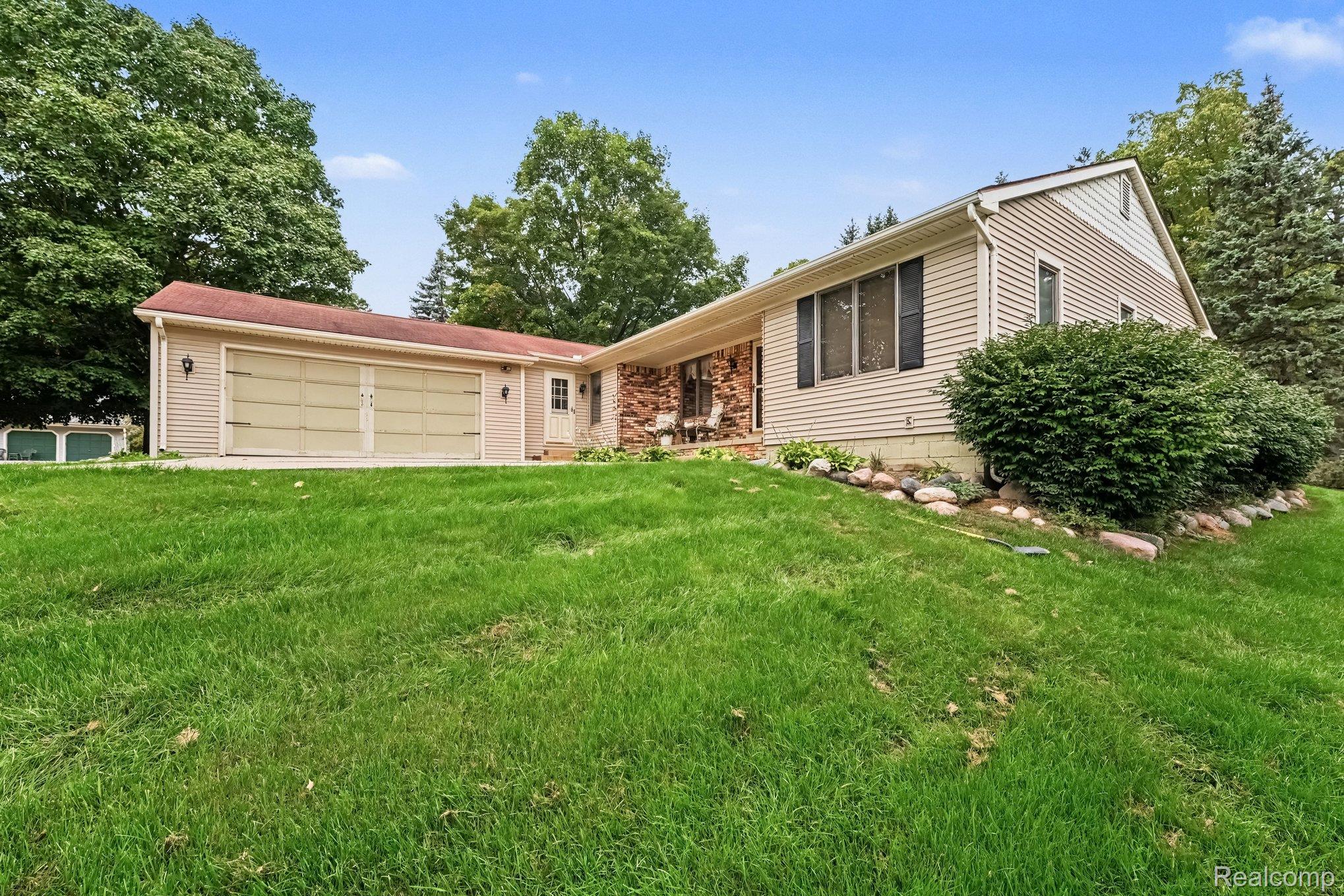 107 Michelle Drive Romeo, MI 48065 - Photo 2 of 30 Siding exterior with a two-car garage, brick accents, and established landscaping