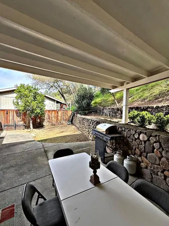 a living room with patio furniture and a garden