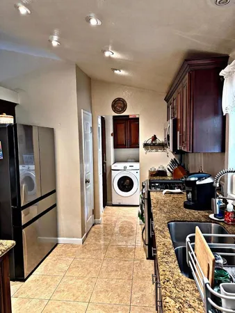 a kitchen with stainless steel appliances granite countertop a refrigerator and a stove top oven