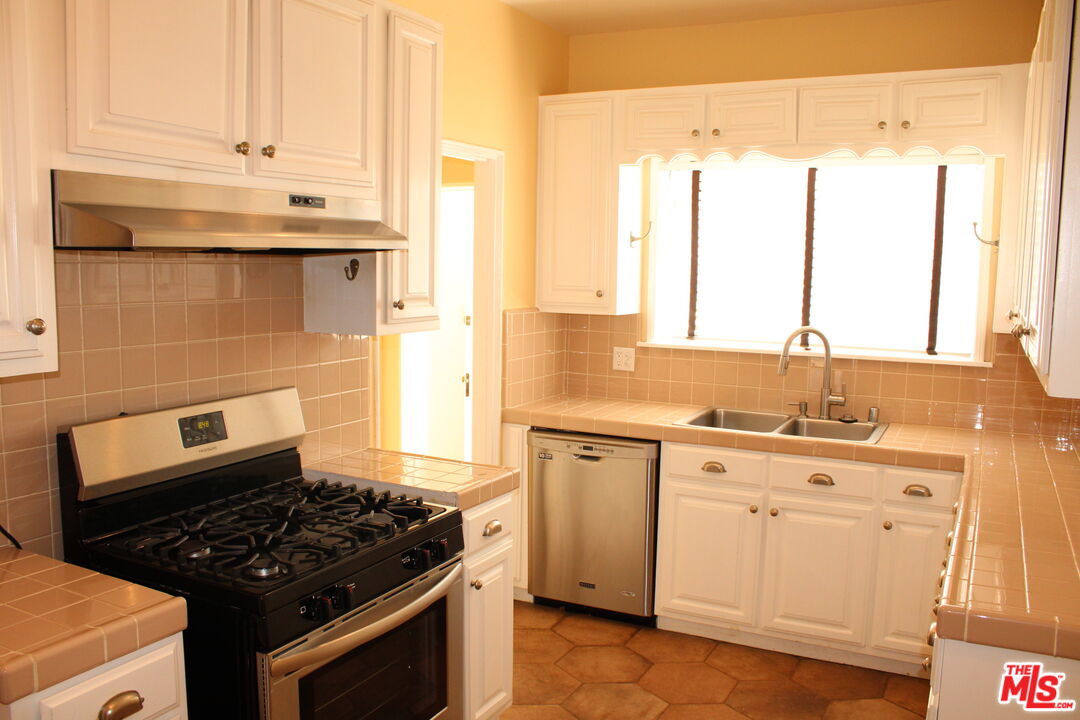 1020 Hi Point Street, Unit 1020 Los Angeles, CA 90035 - Photo 20 of 37 a kitchen with granite countertop a stove a sink and a microwave