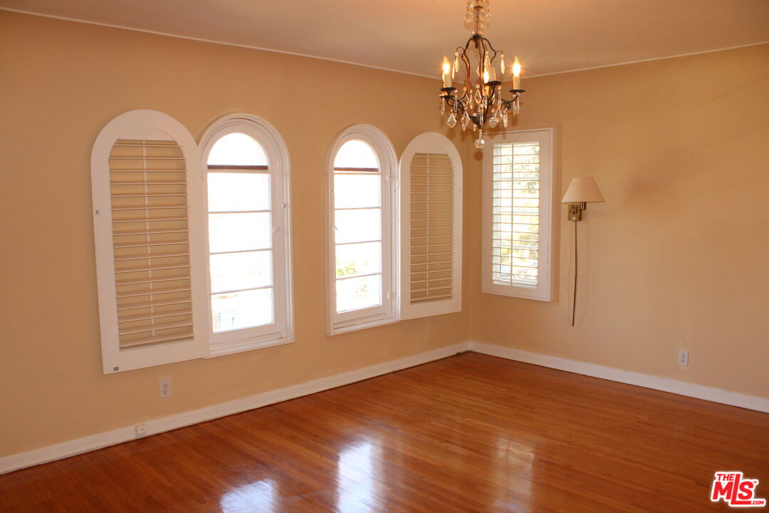 1020 Hi Point Street, Unit 1020 Los Angeles, CA 90035 - Photo 34 of 37 a view of a room with wooden floors and chandelier