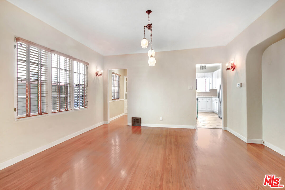 1020 Hi Point Street, Unit 1020 Los Angeles, CA 90035 - Photo 4 of 18 a view of an empty room with wooden floor and a window