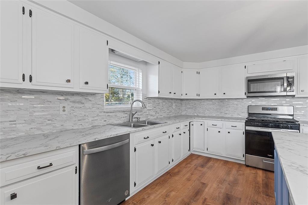 5018 Grove Road Pittsburgh, PA 15234 - Photo 19 of 41 a kitchen with granite countertop white cabinets white stainless steel appliances with a sink and dishwasher