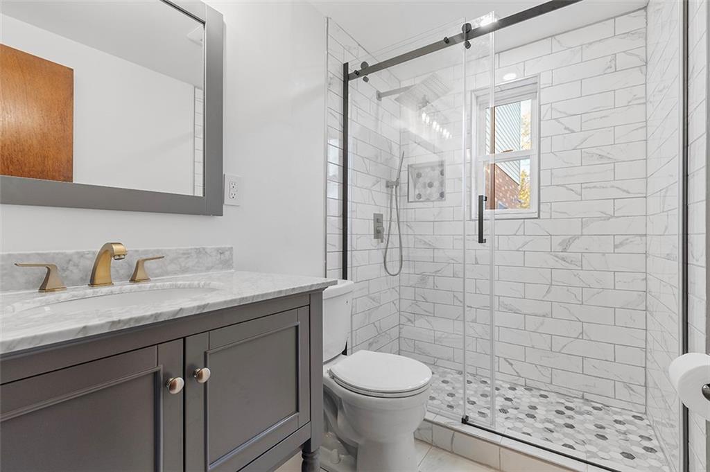 5018 Grove Road Pittsburgh, PA 15234 - Photo 22 of 41 a bathroom with a granite countertop sink a toilet and shower