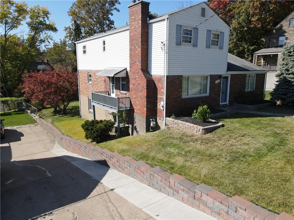 5018 Grove Road Pittsburgh, PA 15234 - Photo 38 of 41 a view of a brick house with many windows next to a yard