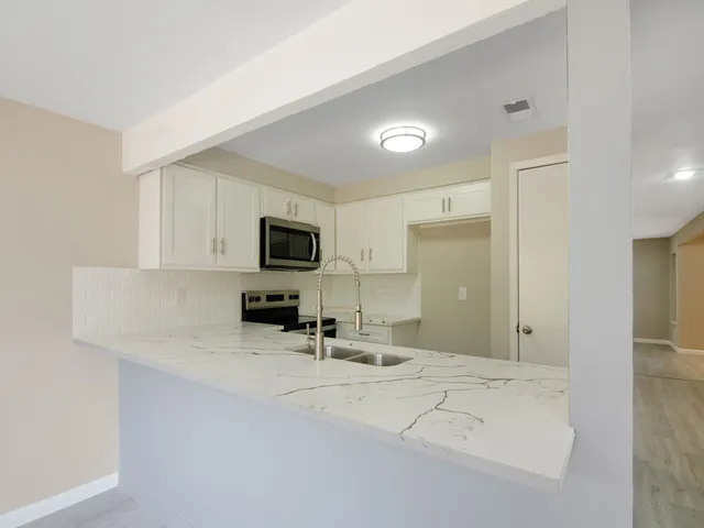 a view of a kitchen with microwave and cabinets