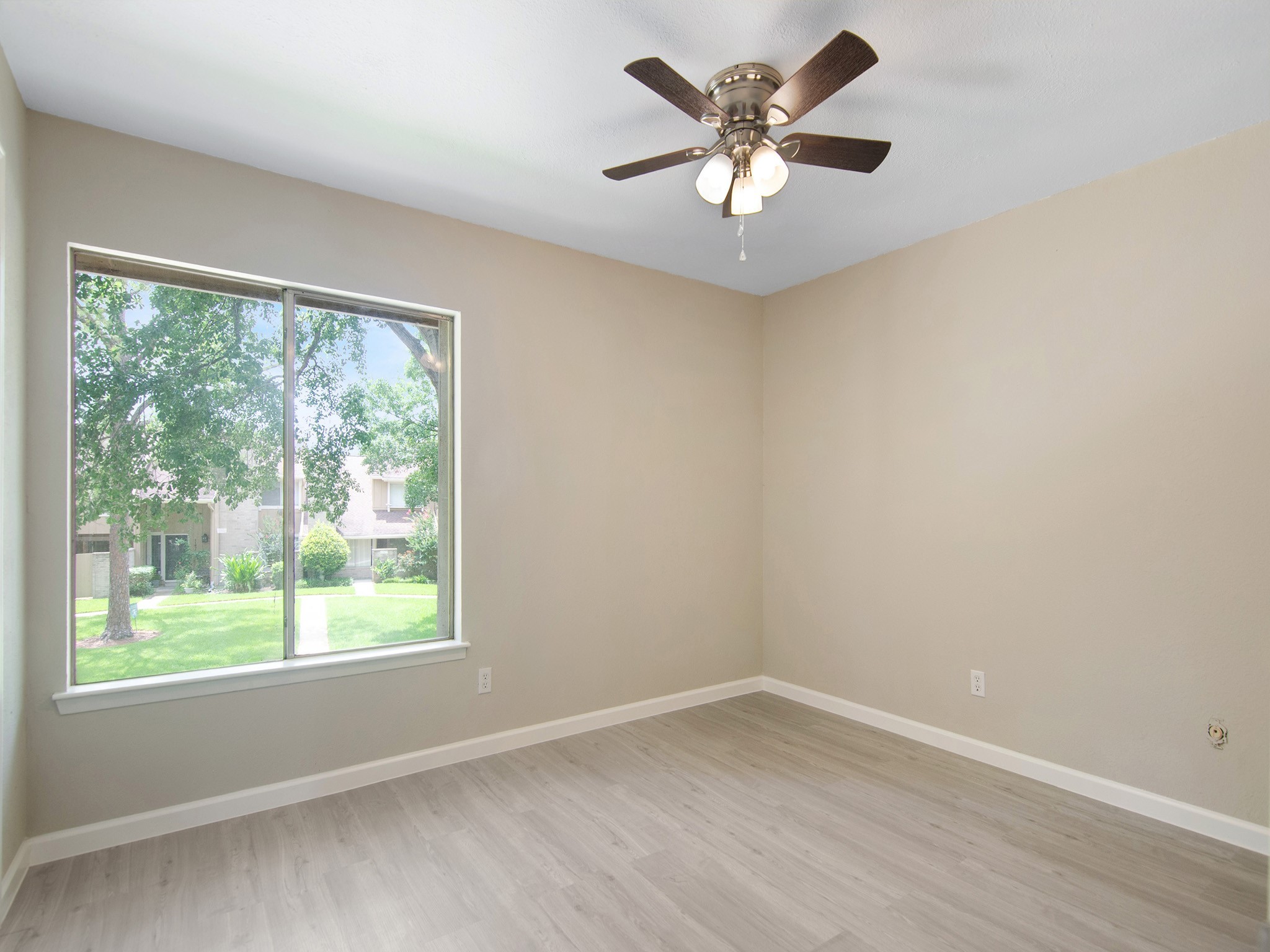 11624 Village Pl Drive, Unit 327 Houston, TX 77077 - Photo 21 of 24 a view of an empty room with a window and a ceiling fan