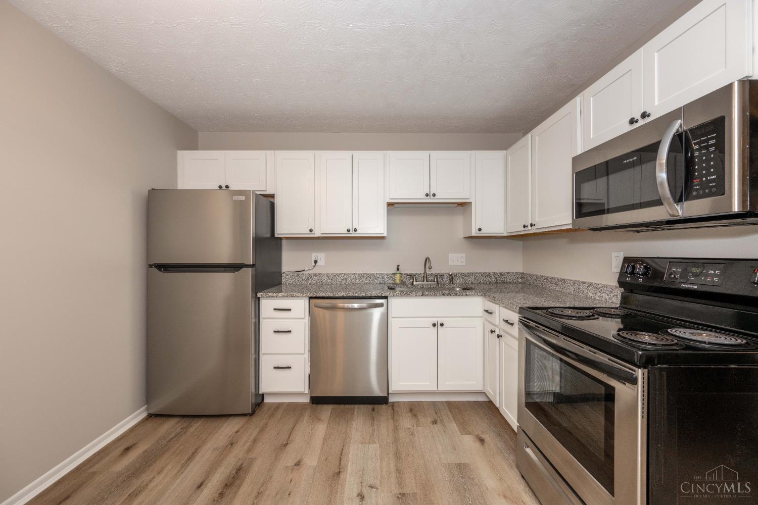 518 Riddle Road, Unit 7 Cincinnati, OH 45220 - Photo 4 of 43 Recently updated kitchen with granite countertops, LVP flooring, and a full suite of appliances, including an oven/range, refrigerator, microwave, and dishwasher.