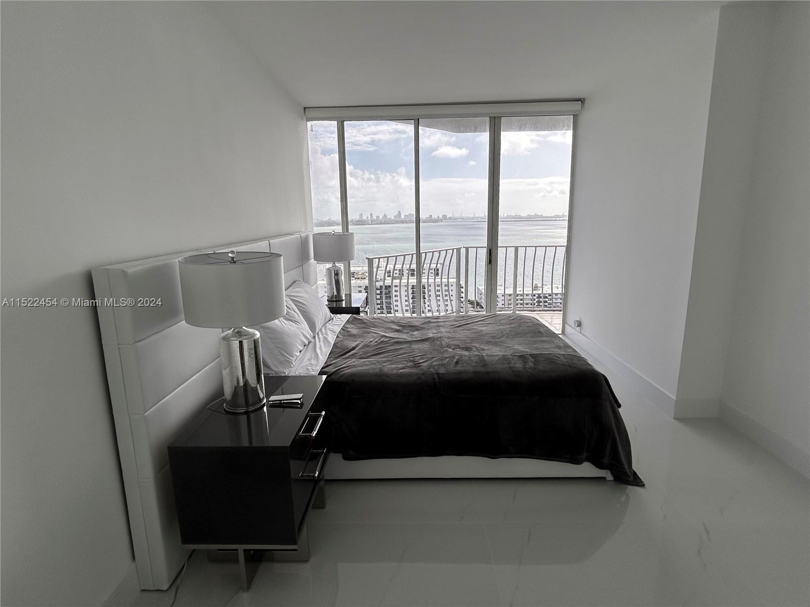 7601 East Treasure Drive, Unit PH206 North Bay Village, FL 33141 - Photo 13 of 24 a bedroom with a bed chair and window