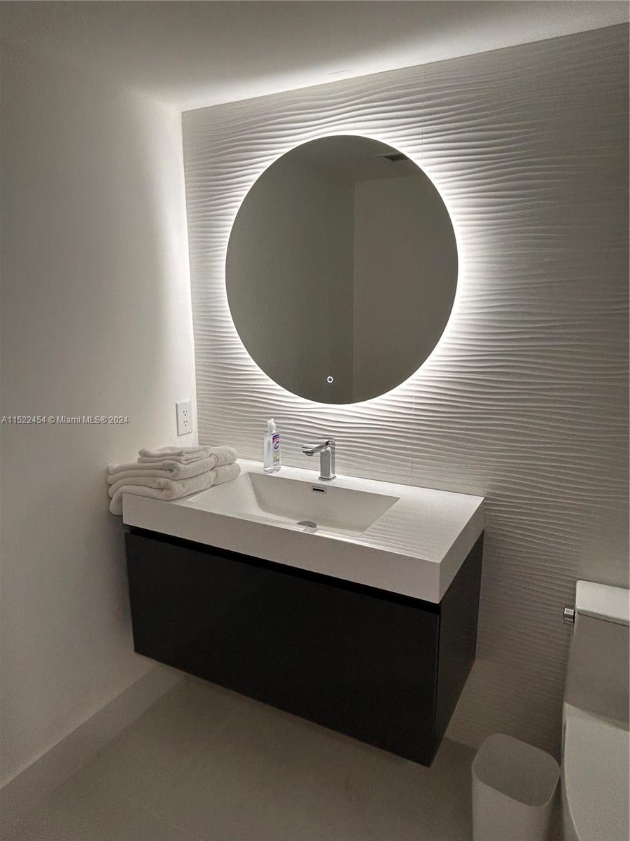 7601 East Treasure Drive, Unit PH206 North Bay Village, FL 33141 - Photo 18 of 24 a bathroom with a sink and a mirror