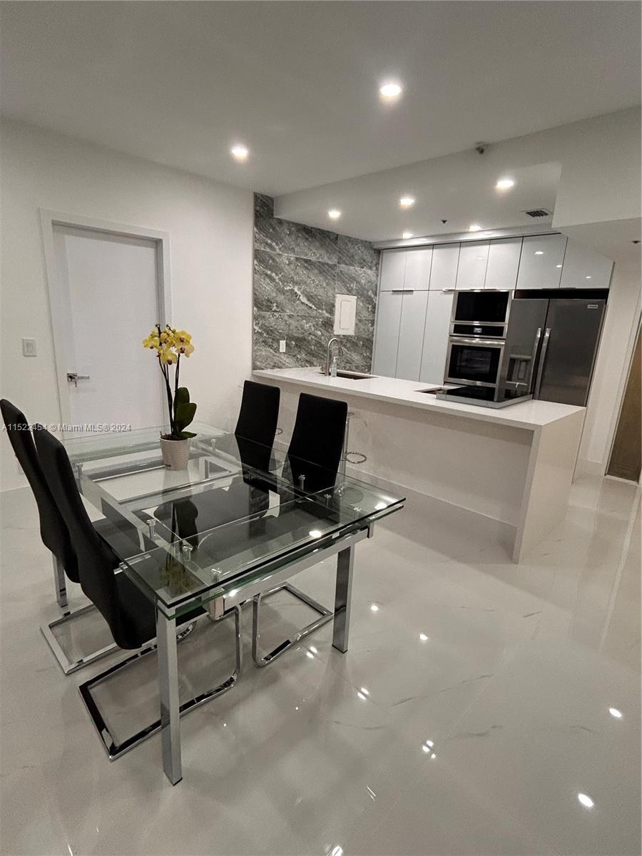 7601 East Treasure Drive, Unit PH206 North Bay Village, FL 33141 - Photo 7 of 24 a workspace with furniture and a table