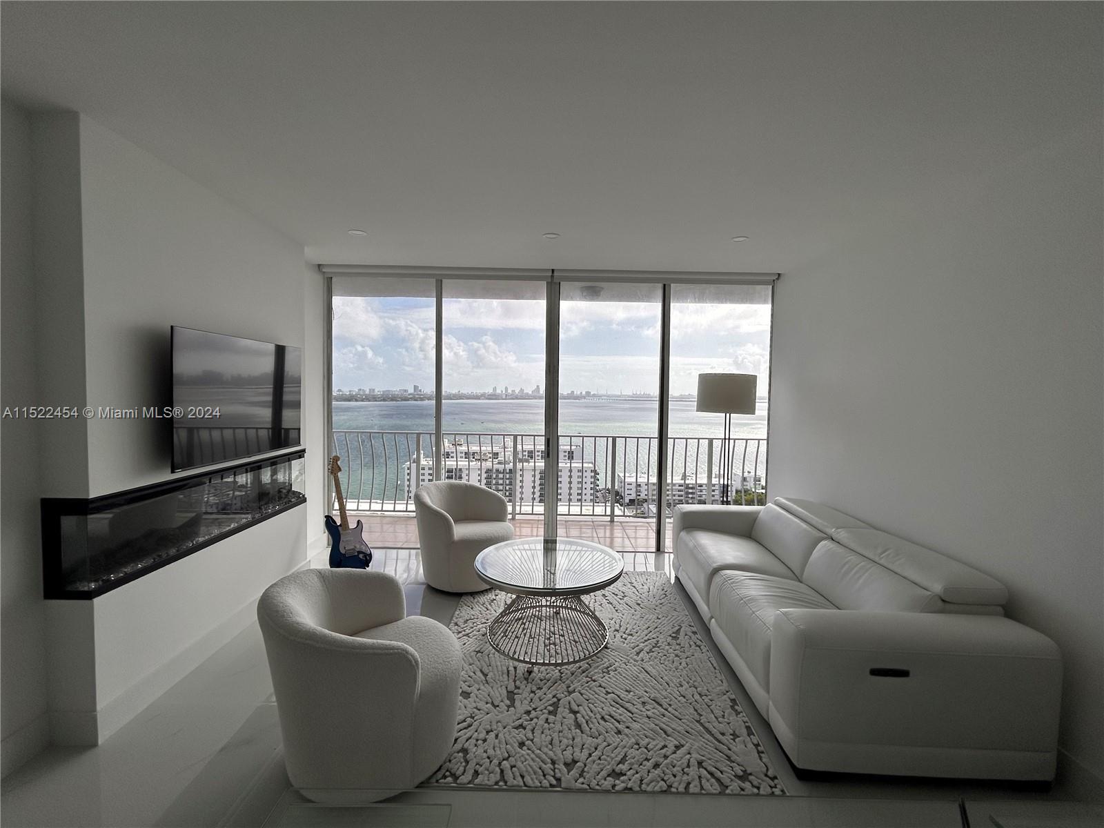 7601 East Treasure Drive, Unit PH206 North Bay Village, FL 33141 - Photo 10 of 24 a living room with furniture and a flat screen tv