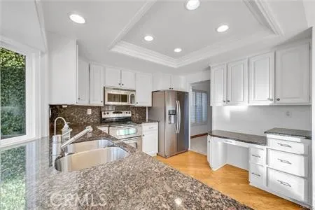 a kitchen with granite countertop a refrigerator sink and stove