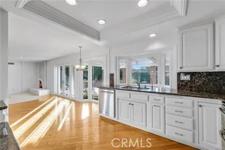 a large white kitchen with granite countertop a large window and white appliances