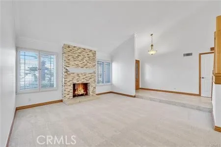 an empty room with windows and fireplace