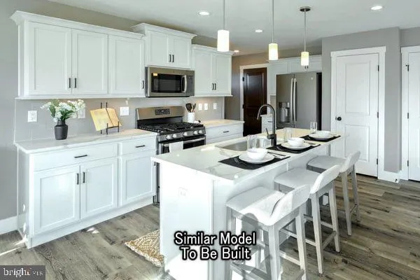 a kitchen with stainless steel appliances kitchen island granite countertop a stove a sink a refrigerator and a microwave