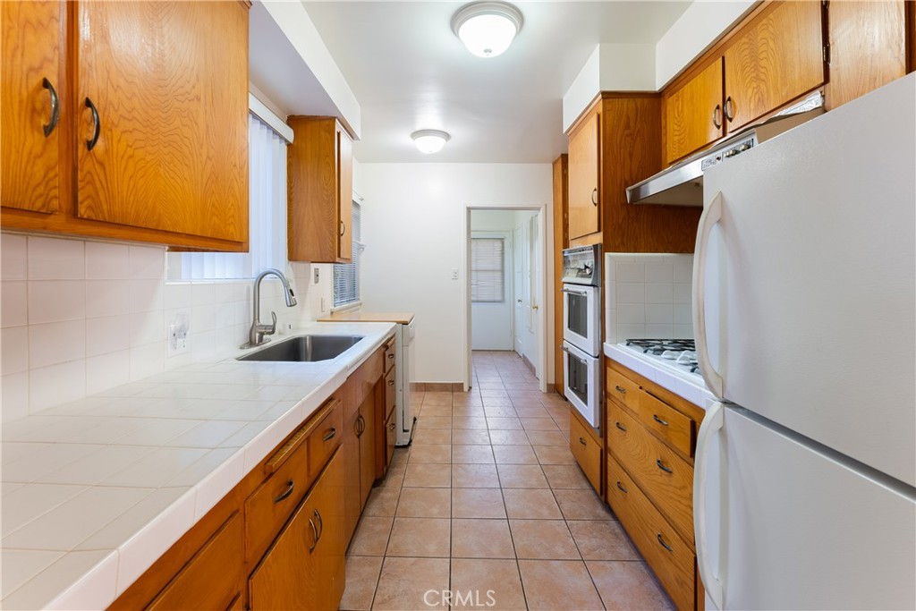 15207-15203 Greenleaf Street Sherman Oaks, CA 91403 - Photo 18 of 32 a kitchen with stainless steel appliances a sink and cabinets