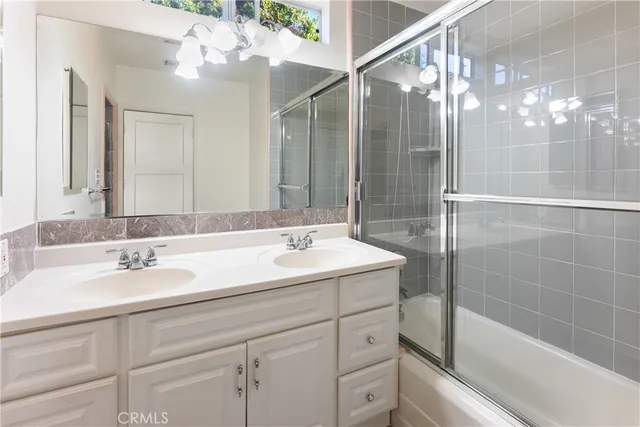 a bathroom with a sink shower and a mirror
