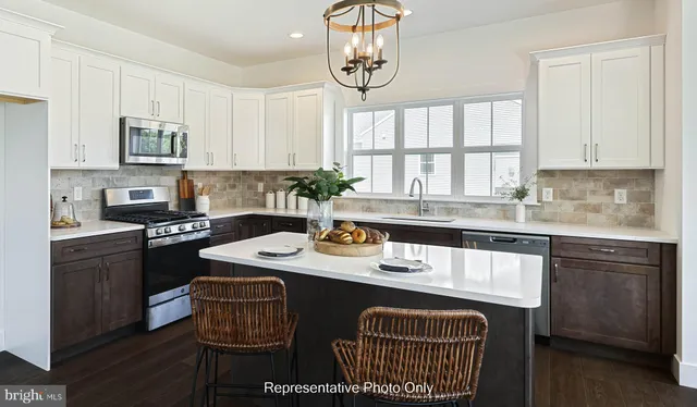 a kitchen with stainless steel appliances granite countertop a sink stove and cabinets