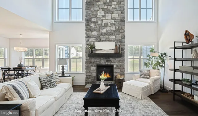 a living room with furniture fireplace and a large window