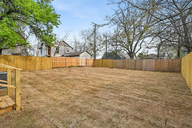 a view of backyard with wooden fence