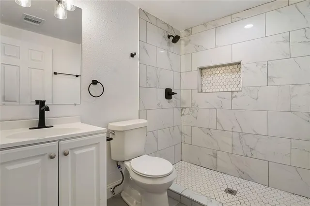 a bathroom with a sink toilet and shower