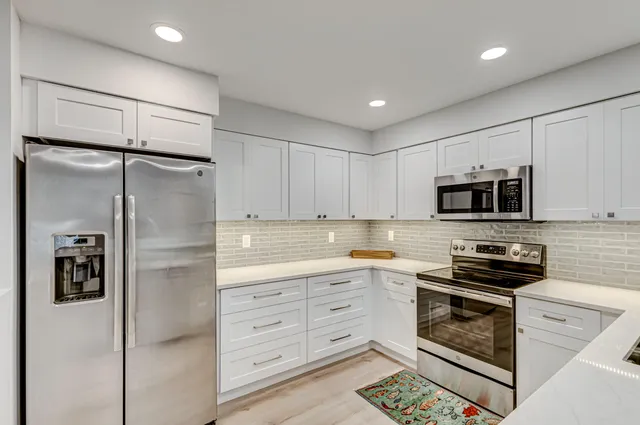 a kitchen that has a sink cabinets and wooden floor