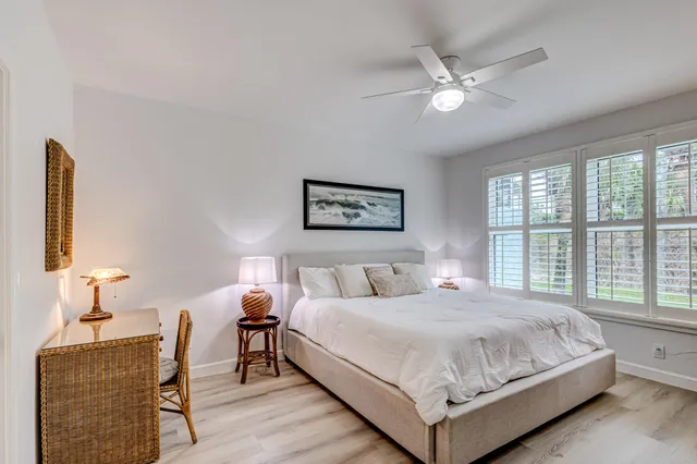 a bedroom with a bed a dresser next to a window